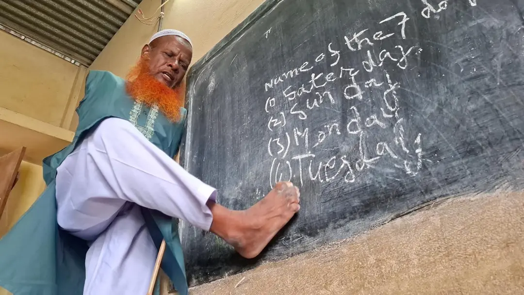 দুই হাত নেই, তবু থামেনি লড়াই, পা দিয়ে পড়ান ১৪৫ শিশু